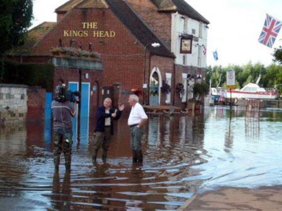 Television crew interviewing a resident outside a flooded Public House, seen in York, Yorkshire
