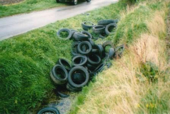 Fly tipped tyres in a drainage ditch